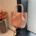 Detalle de bolso saco plisado rosa pálido con asas dobles y correa de hombro fina - Rosa