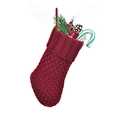 Red knit Christmas stocking with chunky cable pattern and festive holiday decorations - Red