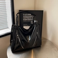 Detalle de bolso tote negro brillante con cremalleras diagonales decorativas al frente - Negro