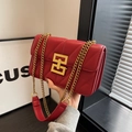 Detailaufnahme der roten Stepptasche aus Leder mit V-Nähten und goldener Kettenriemen - Rot