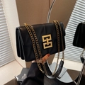 Detail der schwarzen Chevron-Steppung mit goldenem Metallschloss an der Handtasche - Schwarz