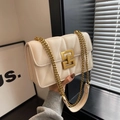 Nahaufnahme der cremefarbenen Stepptasche mit V-Nähten und goldener Gliederkette - Gebrochenes Weiß