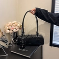 Detail der schwarzen Lacklederhandtasche mit silbernen Beschlägen und Schleife - Schwarz