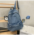 Detail eines blauen Denim-Rucksacks mit Multi-Taschen-Design und Waschungseffekt - Vintage-Blau