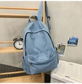 Détail du sac à dos en jean bleu clair avec poche avant et bretelles réglables - Bleu clair