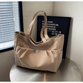 Detalle del bolso tote beige con bolsillos laterales y diseño de textura plisada - Caqui