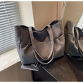 Detalle de la textura lateral y las correas anchas de este bolso tote gris carbón elegante - Gris