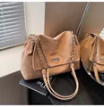 Detail of apricot tote bag featuring silver chain strap and metal logo plaque detail - Khaki