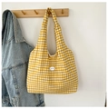 Detail of a yellow and white gingham tote bag with a 'good' patch on a wall hook - Yellow
