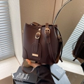 Dunkelbraune Eimer-Tasche aus Kieselleder mit goldfarbenen Beschlägen und Kordelzug - Kaffeebraun