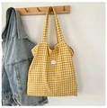 Yellow and white gingham tote bag with a white 'good' patch shown on a wooden hanger - Yellow