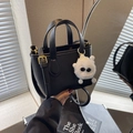 Black lychee leather mini bucket bag with gold hardware and plush monster charm - With Charm / Black