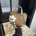 Chic beige lychee leather mini bucket bag with a playful white plush monster charm - With Charm / Sand