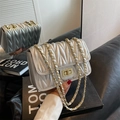 Elegant silver quilted chain bag featuring V-shaped stitching and golden twist lock - Silver