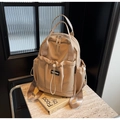 Detalle de mochila de nailon caqui con múltiples bolsillos sobre mesa de mármol - Caqui