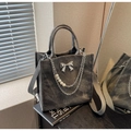 Detalle de bolso tote de ante gris oscuro con lazo plateado y cadena de perlas decorativa - Marrón Oscuro