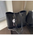 Detalle de bolso tote de cuero negro con grabado lichi, costuras y colgante suave - Negro (Con Colgante)