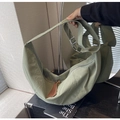 Detalle del bolso de nailon gris verde con correa ajustable y tirador de cremallera de cuero - Verde