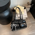 Chic black patent leather Boston bag with utilitarian pockets and pearl bow accessory - Black