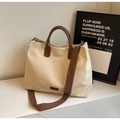 Minimalistische beige Nylon-Tragetasche mit dunkelbraunen Ledergriffen und Web-Schultergurt - Beigegrau