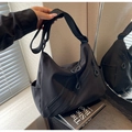 Dettaglio della borsa hobo in tela nera con tasche multiple a zip e tracolla regolabile - Nero