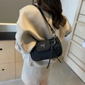 Black vintage shoulder bag with silver bow buckle and heart charm on mannequin - Black