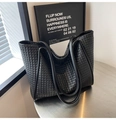 Close-up detail of the intricate black woven pattern and sturdy handles on the tote bag - Black