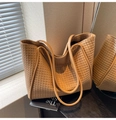 Detail view of brown woven leather texture and handles on a large capacity tote bag - Khaki
