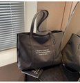 Dettaglio della borsa tote in tela grigio scuro con stampa testuale e manici robusti - Marrone Scuro