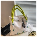 Primer plano detallado de un bolso tote de nailon blanco con asas acolchadas verdes y logo - Blanco