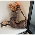 Detail of dark brown hobo bag with knotted shoulder strap and sleek metal zipper closure - Brown