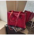 Détail d'un sac de mariée rouge foncé avec dentelle florale et un grand nœud élégant - Rouge
