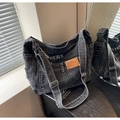 Dettaglio della borsa a tracolla in denim grigio scuro con tasche vintage e tracolla - Nero