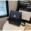 Detalle de la mochila con hebilla metálica de mariposa y diseño patchwork de cuero - Negro