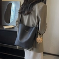 Bolso saco negro de cuero con grabado lichi, colgante de peluche marrón y letras doradas - Negro (Con Colgante)