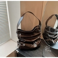Gros plan d'un sac à bandoulière marron foncé plissé avec une texture en cuir brillant chic - Marron
