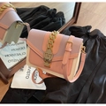 Bolso bandolera rosa y crema con cadena dorada sobre elegante tejido de seda negra - Púrpura y Rosa