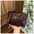 Detailed view of dark brown quilted crossbody bag with triangle logo and silver chain strap - Brown