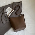 Dark brown pebbled leather bucket bag with adjustable strap on a minimalist background - Coffee (No Pendant)