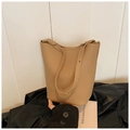 Elegante borsa a secchiello beige con fiocco dorato e tracolla su giacca di pelle - Albicocca