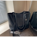 Primer plano de bolso tote negro con textura retro y logo dorado en escritorio - Negro