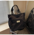 Dettaglio laterale della borsa tote in nylon nero con logo in pelle e tasca laterale - Nero