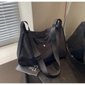 Primer plano de bolso hobo de nailon negro con correa ajustable y broche plateado - Negro