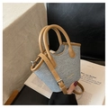 Mini-Bucket-Bag aus Denim mit braunem Lederbesatz und runden Griffen auf Magazin - Denim-Textur / Blau