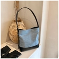 Detalle del bolso tipo cubo de patchwork vaquero con correa ajustable de cuero negro - Denim Negro