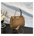 Detail of tan pebble leather bag featuring a gold turn-lock closure and sturdy top handle - Khaki