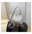 Detailed shot of silver lychee texture bag with gold twist lock and handle held by hand - Silver