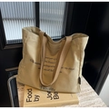 Detailansicht der khakifarbenen Canvas-Tasche mit braunen Gurten und schwarzem Text - Khaki