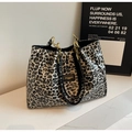 Detail shot of leopard print tote bag with black leather handle and gold chain accents - Black
