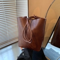 Minimalist brown bucket shoulder bag with geometric patchwork texture and knotted strap - Brown